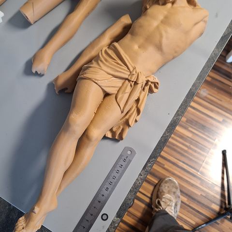 Gedruckte Christusfigur mit angesetzten Armen auf der Werkbank