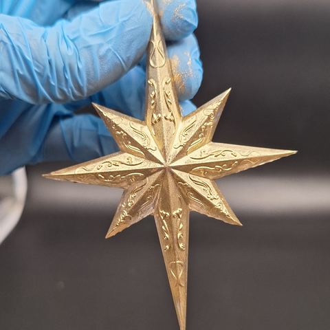 Goldener achtzackiger Stern in der Hand