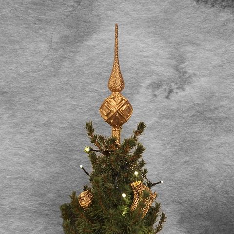 Goldene Christbaumspitze vor grauem Hintergrund