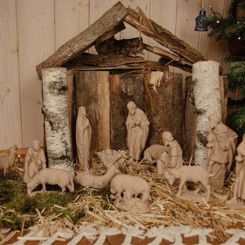 Weihnachtskrippe mit gedruckten Figuren im Holzstall